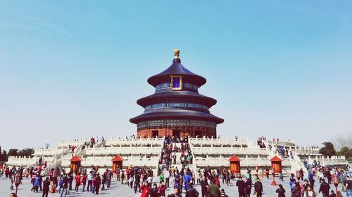 People at temple against clear sky