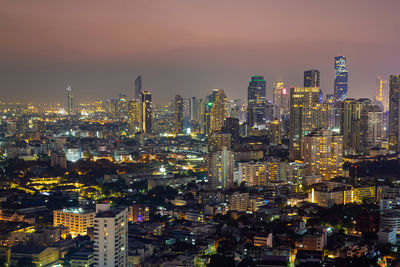 Illuminated cityscape against sky at night