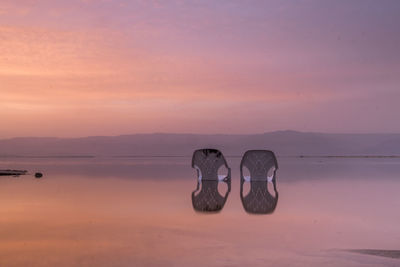 View of shoes on beach against sky during sunset