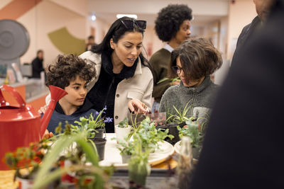 Mother with sons buying plants while shopping at recycling center