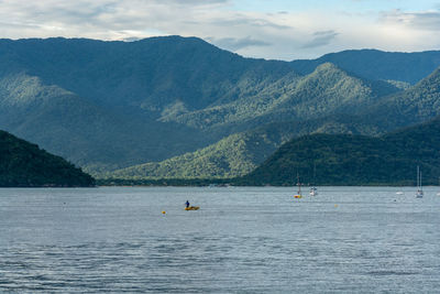 Scenic view of sea and mountains against sky