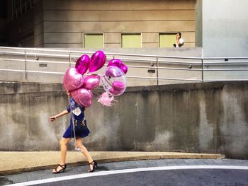 Rear view of a woman walking on road