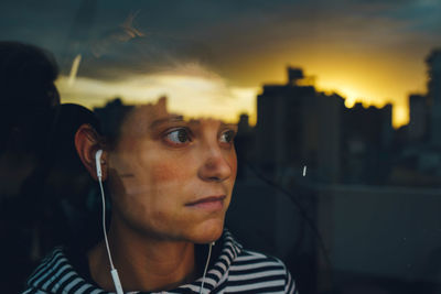 Close-up of woman looking away seen through window