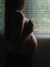 Rear view of a man looking through window