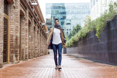 Full length of woman walking on footpath in city