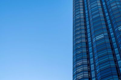 Low angle view of modern building against clear blue sky