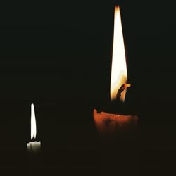 Lit candle in dark room