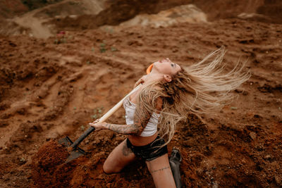 Young girl digs sand with a shovel