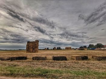 Hay bales on field against sky