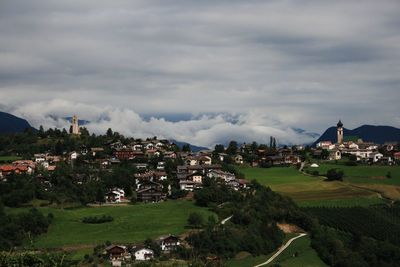 Houses in town against cloudy sky