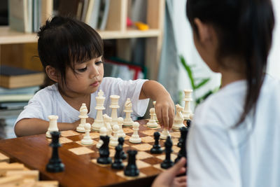 Siblings playing chess at home