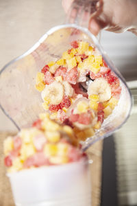 Close-up of hand holding ice cream on table