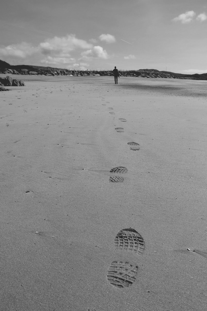 sand, beach, sky, shore, sea, tranquility, tranquil scene, leisure activity, lifestyles, walking, nature, scenics, men, cloud - sky, footprint, beauty in nature, day, incidental people