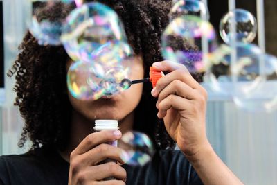 Close-up of young woman blowing bubbles