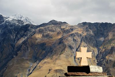 Cross at caucasus mountains against sky