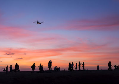 Silhouette people at beach during sunset