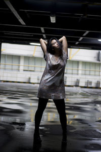 Full length of young woman standing in building