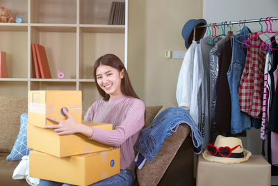 Portrait of smiling young woman sitting in box at store