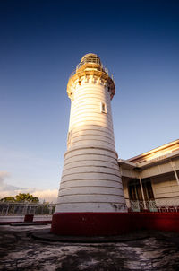 Low angle view of lighthouse against buildings