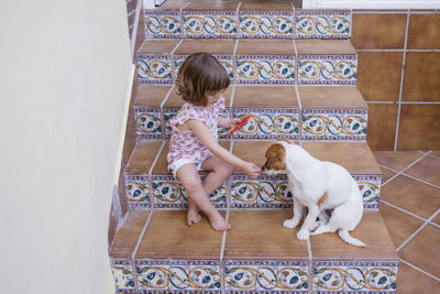 Full length of woman with dog on tiled floor