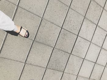 Low section of woman standing on tiled floor