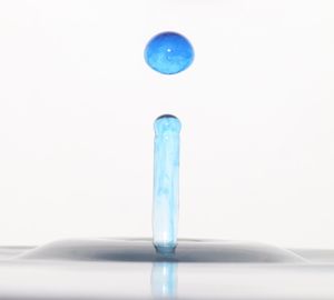 Close-up of blue glass against white background