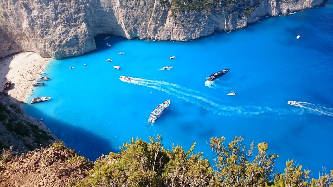 transportation, water, mode of transport, blue, high angle view, tree, flying, scenics, nature, tranquility, beauty in nature, tranquil scene, nautical vessel, travel, mountain, sea, aerial view, day, idyllic, mid-air