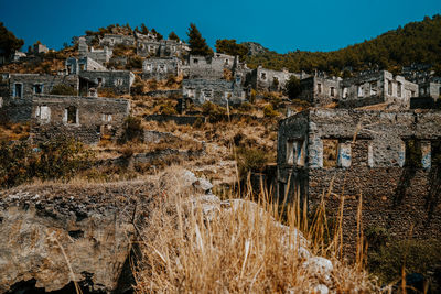 Old building by mountain against sky