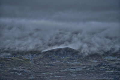 Scenic view of mountains against cloudy sky