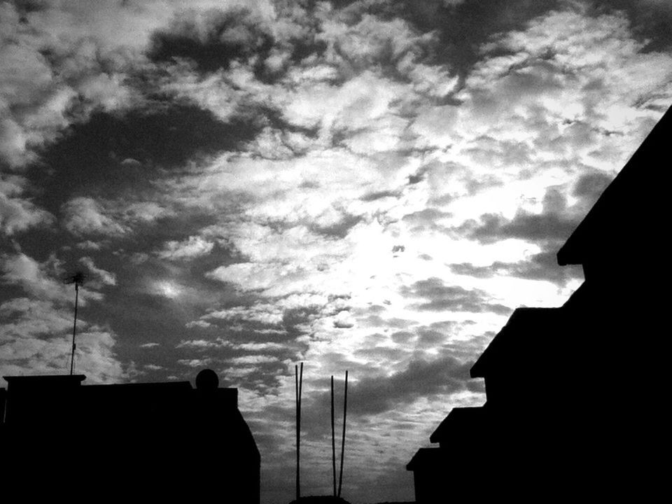 SILHOUETTE OF BUILDING AGAINST CLOUDY SKY