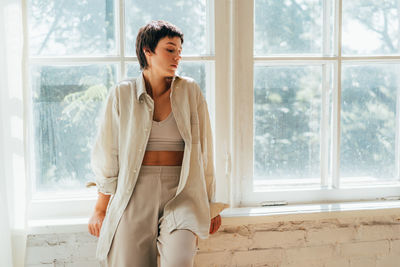 Side view of young woman looking through window