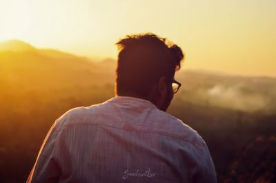 Rear view of man looking at sunset