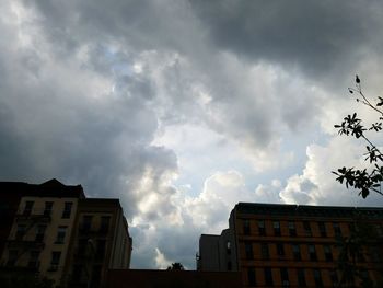 Low angle view of buildings against cloudy sky