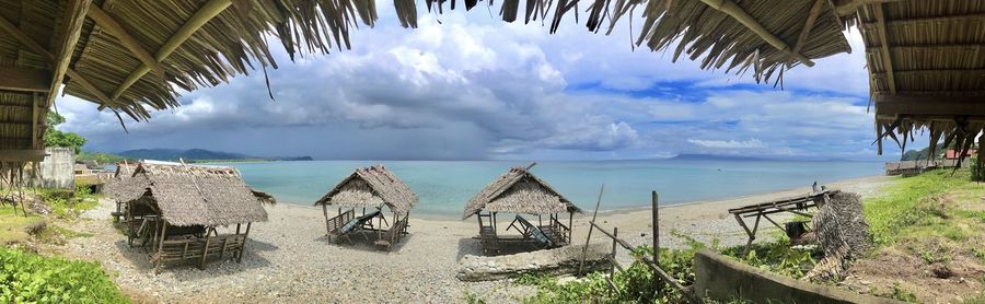 Panoramic view of people on beach against sky