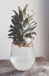 Close-up of glass jar on table against wall