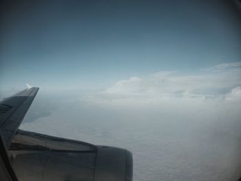 Airplane flying over sea against sky