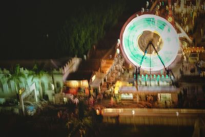 Illuminated ferris wheel in city at night