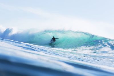 Man surfing in sea against sky