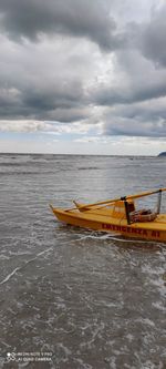 Boat moored in sea against sky