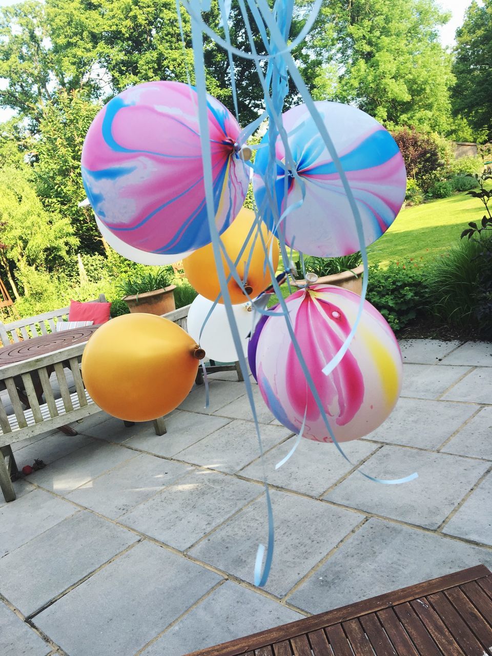 multi colored, hanging, sunlight, decoration, flower, balloon, outdoors, day, tree, celebration, table, chair, umbrella, high angle view, no people, park - man made space, shadow, front or back yard, pink color, fragility