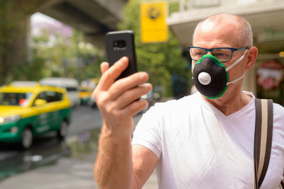 Portrait of man using mobile phone in bus