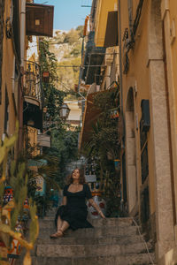 Rear view of woman sitting on street