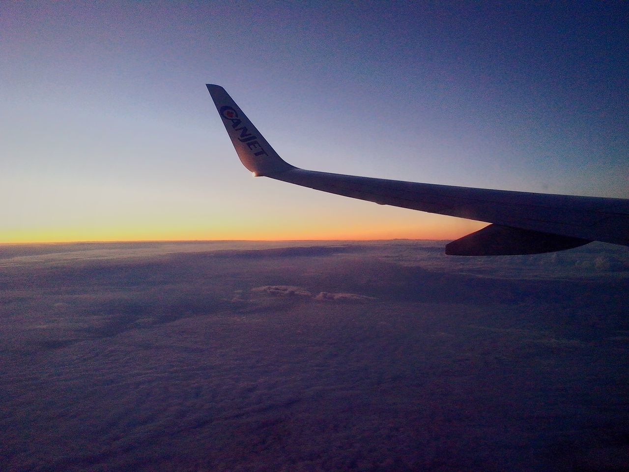 airplane, sunset, aircraft wing, air vehicle, flying, transportation, landscape, mode of transport, sky, travel, scenics, aerial view, beauty in nature, nature, orange color, part of, clear sky, tranquil scene, tranquility, outdoors