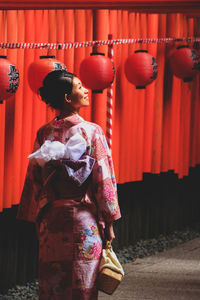 Woman standing with red umbrella