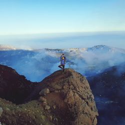 Someone standing at top mountain with back caldera