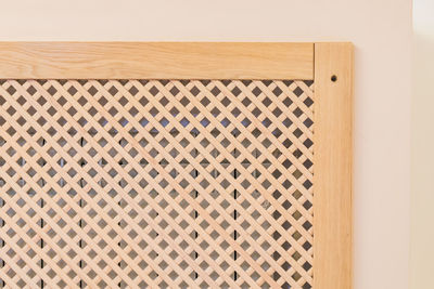 Close-up of wooden heater decorative panel against wall at home