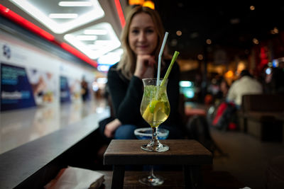 Portrait of woman with drink in bus