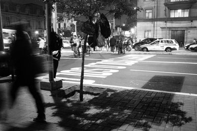 Blur image of person walking on sidewalk in illuminated city