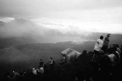 People on mountain against sky