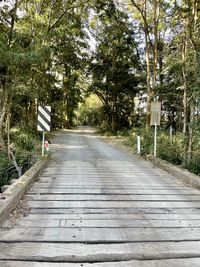 Person walking on footpath by road in forest